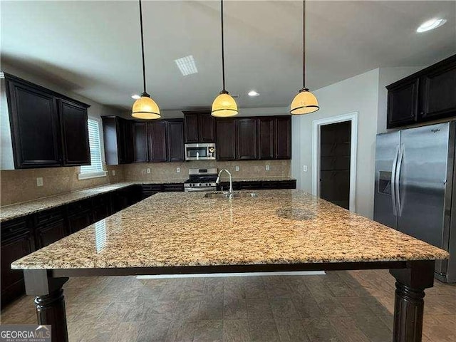 3488 Woodshade Dr, Loganville, GA 30052 - kitchen with appliances with stainless steel finishes, a sink, decorative backsplash, light stone countertops, and a large island
