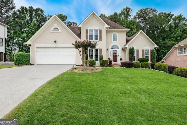 310 Medridge Dr, Alpharetta, GA 30022 - view of front facade featuring driveway, stucco siding, a garage, and a front lawn