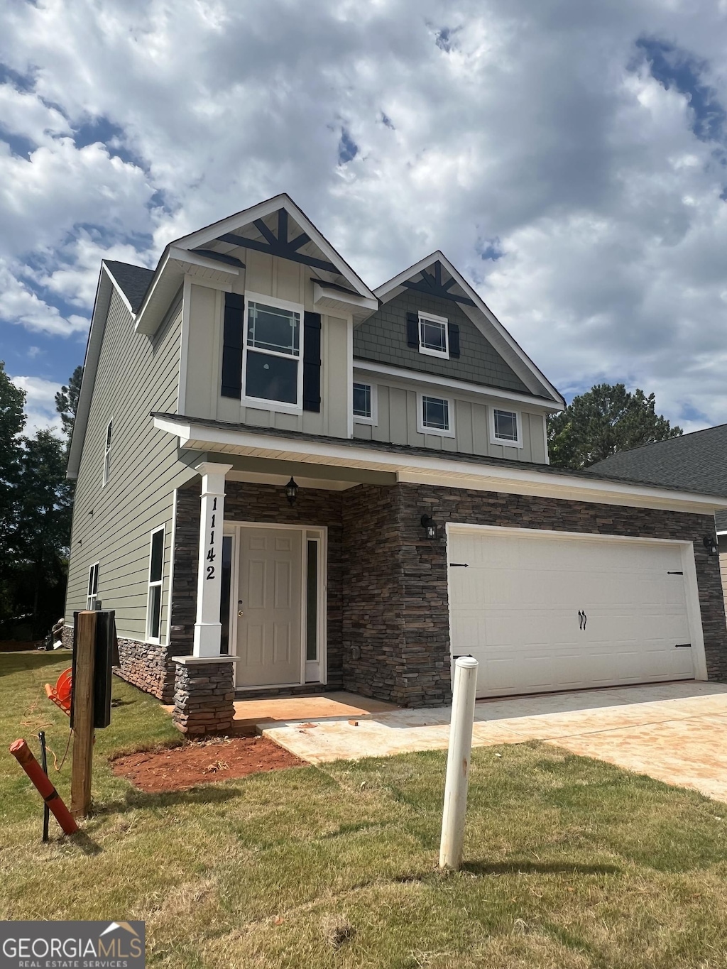 11142 Cornerstone Way, Hampton, GA 30228 - craftsman house featuring board and batten siding, stone siding, a front lawn, and driveway