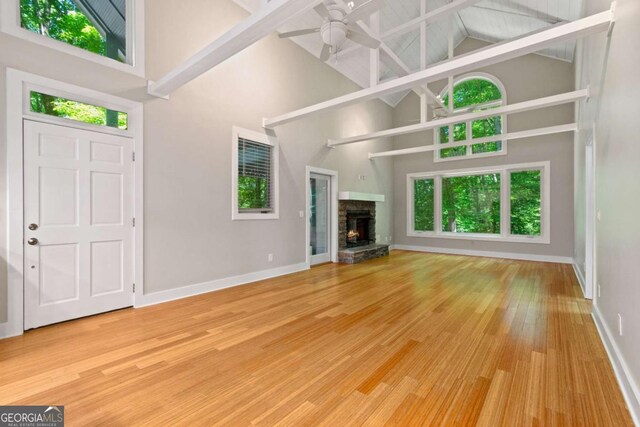 532 Coffee Cove Dr, Jasper, GA 30143 - unfurnished living room featuring high vaulted ceiling, ceiling fan, baseboards, wood finished floors, and a stone fireplace
