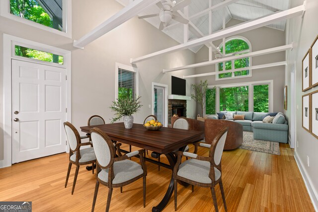 532 Coffee Cove Dr, Jasper, GA 30143 - dining area featuring high vaulted ceiling, a stone fireplace, a ceiling fan, healthy amount of natural light, and light wood-type flooring