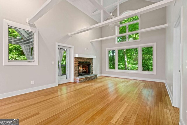 532 Coffee Cove Dr, Jasper, GA 30143 - unfurnished living room featuring baseboards, wood finished floors, a fireplace, and a towering ceiling