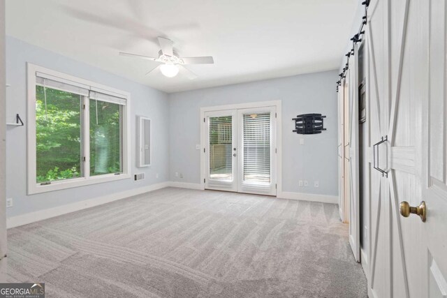 532 Coffee Cove Dr, Jasper, GA 30143 - spare room with baseboards, light colored carpet, ceiling fan, and a barn door