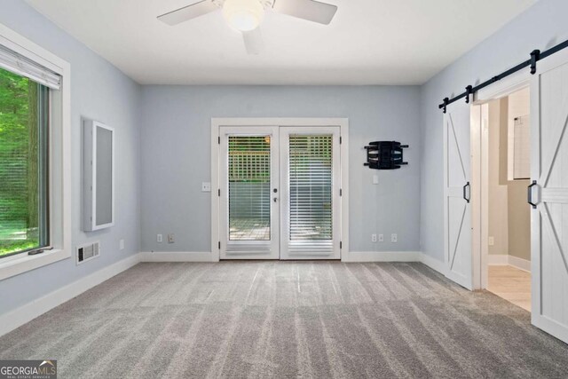 532 Coffee Cove Dr, Jasper, GA 30143 - carpeted empty room with a barn door, ceiling fan, and baseboards