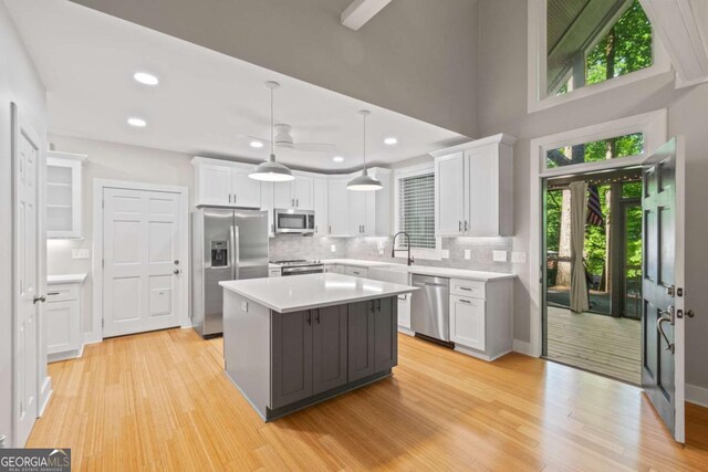 532 Coffee Cove Dr, Jasper, GA 30143 - kitchen with appliances with stainless steel finishes, white cabinets, light countertops, tasteful backsplash, and light wood finished floors