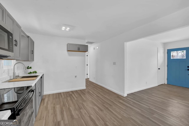 2030 Euclid St, Statham, GA 30666 - kitchen with black range with electric stovetop, gray cabinetry, light wood-style flooring, light countertops, and stainless steel microwave