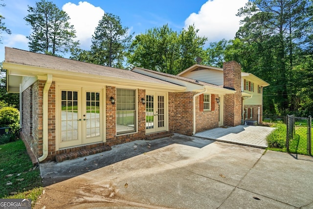 7121 Forest Dr SE, Covington, GA 30014 - rear view of house with french doors, a patio area, brick siding, and a chimney