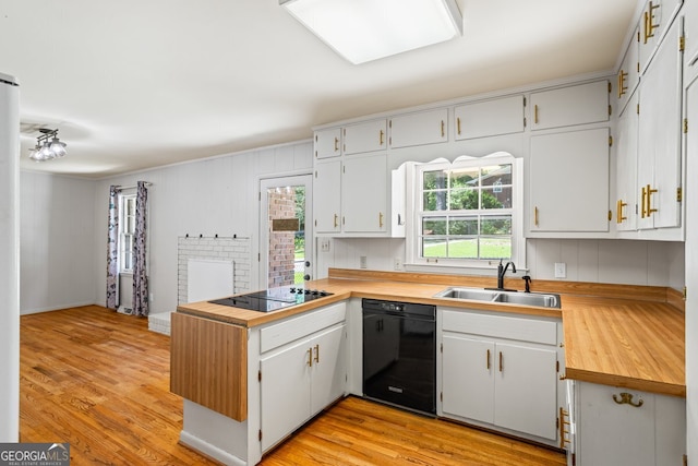 7121 Forest Dr SE, Covington, GA 30014 - kitchen with black appliances, a peninsula, butcher block counters, and light wood-type flooring