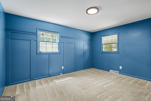 7121 Forest Dr SE, Covington, GA 30014 - unfurnished bedroom featuring a decorative wall, multiple windows, and carpet flooring