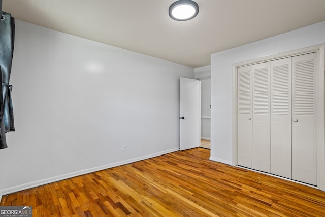 7121 Forest Dr SE, Covington, GA 30014 - unfurnished bedroom with wood finished floors and a closet