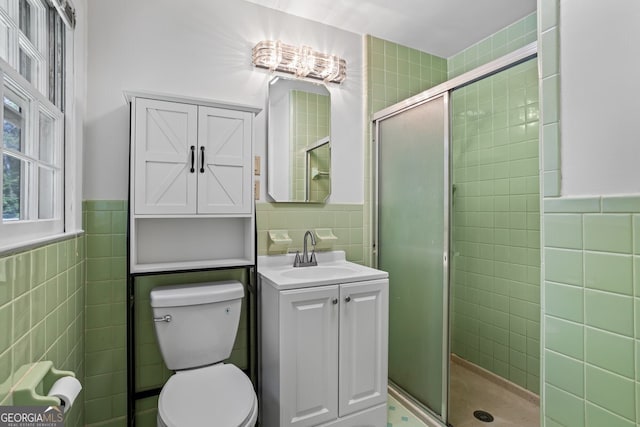 7121 Forest Dr SE, Covington, GA 30014 - bathroom with tile walls, a stall shower, vanity, and a wainscoted wall