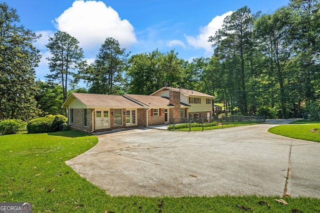 7121 Forest Dr SE, Covington, GA 30014 - tri-level home featuring french doors, concrete driveway, and brick siding