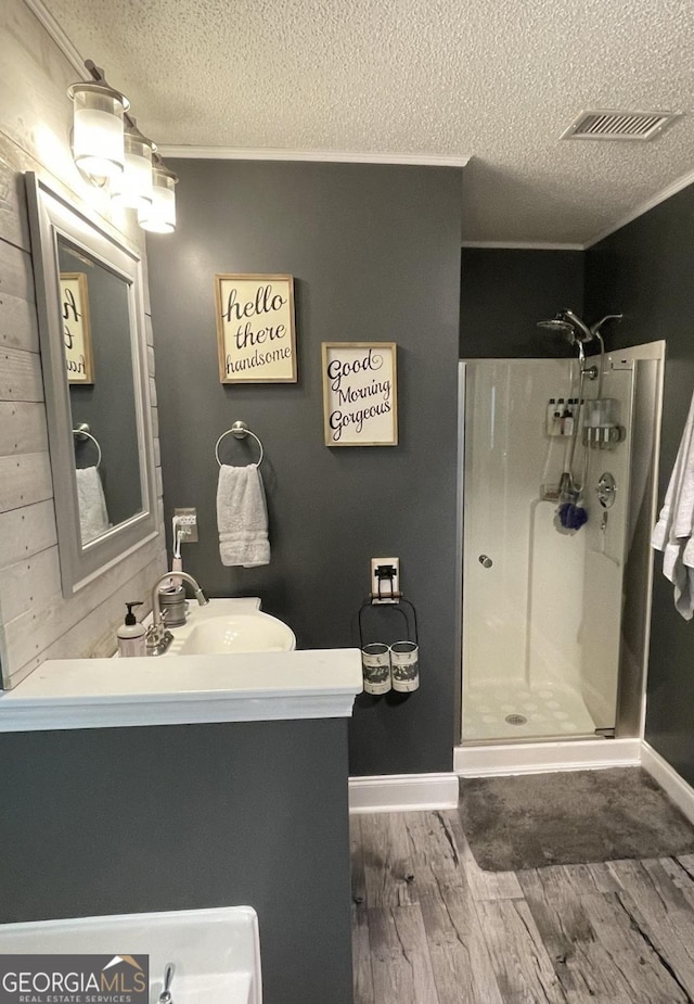 40 Legend Creek Chase, Douglasville, GA 30134 - full bath featuring a shower stall, a textured ceiling, vanity, wood finished floors, and ornamental molding