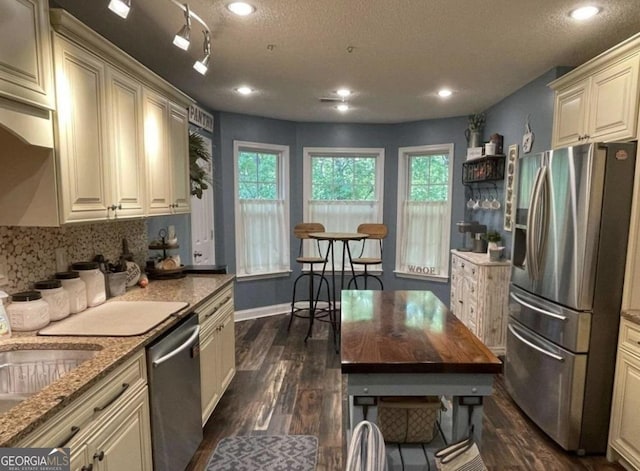 40 Legend Creek Chase, Douglasville, GA 30134 - kitchen with stainless steel appliances, dark wood-style flooring, healthy amount of natural light, dark stone counters, and a textured ceiling