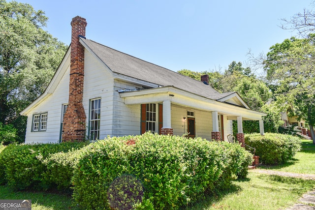 100 Minor Ave, Montezuma, GA 31063 - view of side of property with a chimney, a porch, a yard, and a shingled roof