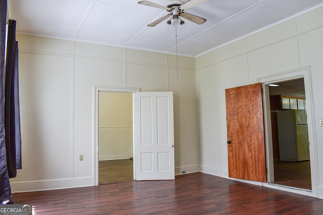 100 Minor Ave, Montezuma, GA 31063 - unfurnished bedroom with freestanding refrigerator, wood finished floors, crown molding, baseboards, and a decorative wall