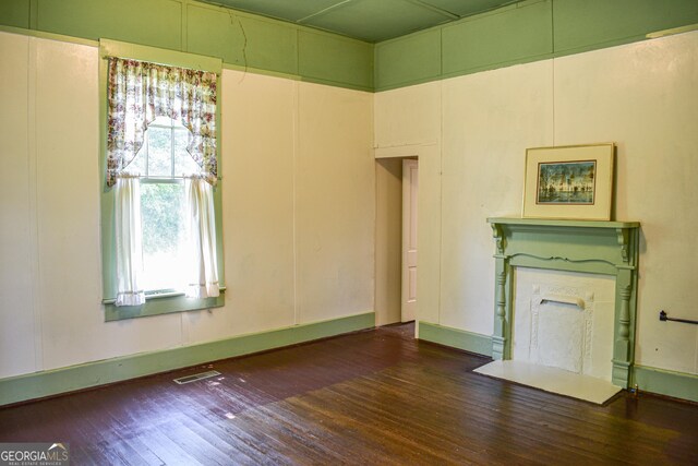 100 Minor Ave, Montezuma, GA 31063 - unfurnished living room with hardwood / wood-style flooring and a fireplace with flush hearth