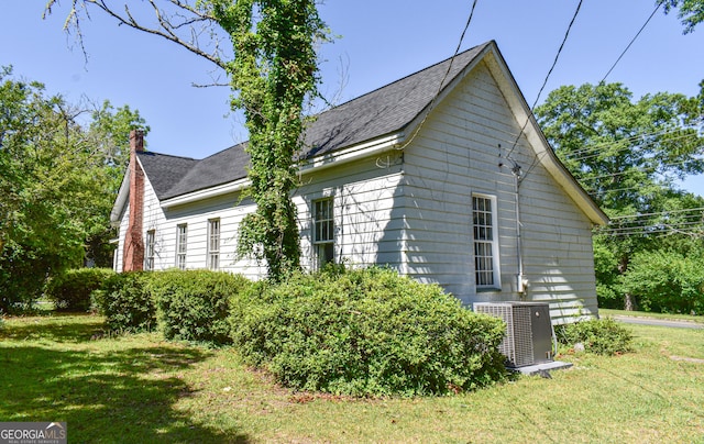 100 Minor Ave, Montezuma, GA 31063 - view of home's exterior with central AC unit, a yard, a chimney, and roof with shingles