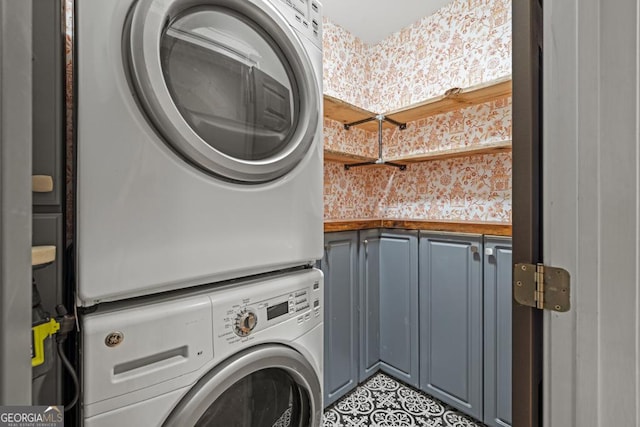 2230 Ewing Chapel Rd, Dacula, GA 30019 - laundry room featuring estacked washer and dryer, cabinet space, and tile patterned floors