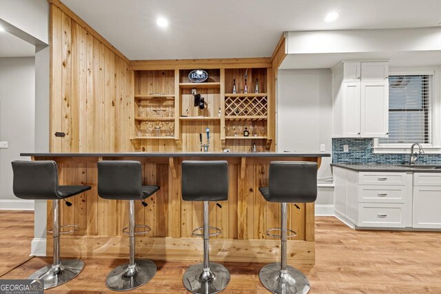 2230 Ewing Chapel Rd, Dacula, GA 30019 - indoor wet bar featuring light wood-type flooring, decorative backsplash, and recessed lighting