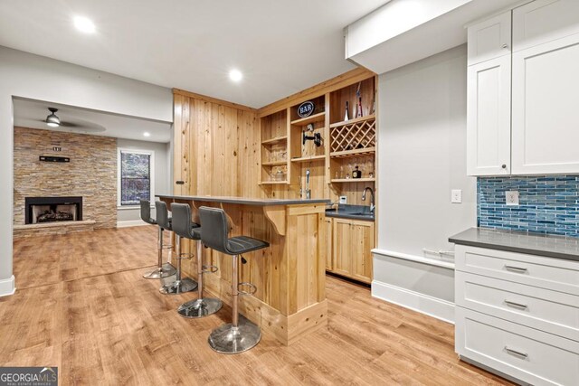 2230 Ewing Chapel Rd, Dacula, GA 30019 - indoor wet bar with a ceiling fan, light wood finished floors, backsplash, a fireplace, and recessed lighting