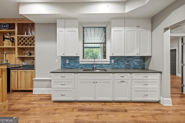 2230 Ewing Chapel Rd, Dacula, GA 30019 - kitchen with dark countertops, white cabinets, backsplash, and light wood finished floors