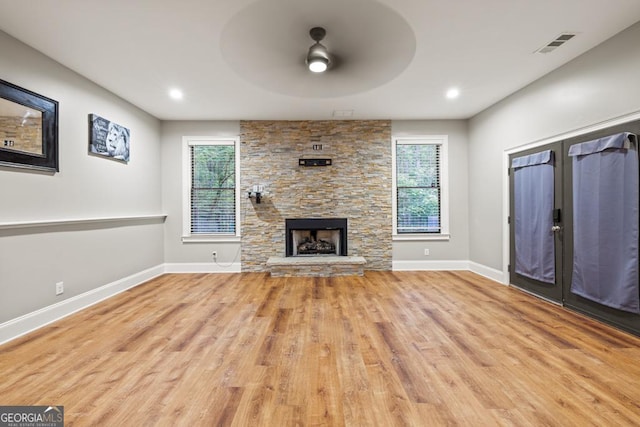 2230 Ewing Chapel Rd, Dacula, GA 30019 - unfurnished living room with a ceiling fan, plenty of natural light, wood finished floors, a stone fireplace, and recessed lighting