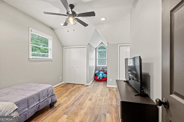2230 Ewing Chapel Rd, Dacula, GA 30019 - bedroom with light wood-style flooring, multiple closets, vaulted ceiling, and ceiling fan