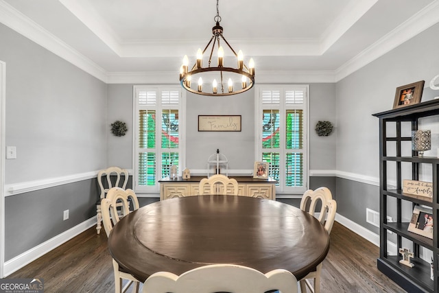 704 Branchview Ct, Mcdonough, GA 30252 - dining area featuring a raised ceiling, a chandelier, dark wood-style floors, and crown molding