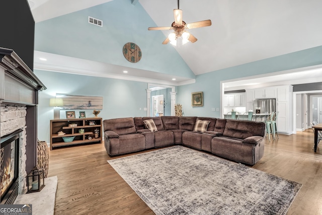 704 Branchview Ct, Mcdonough, GA 30252 - living room featuring high vaulted ceiling, a ceiling fan, a stone fireplace, and light wood-style flooring