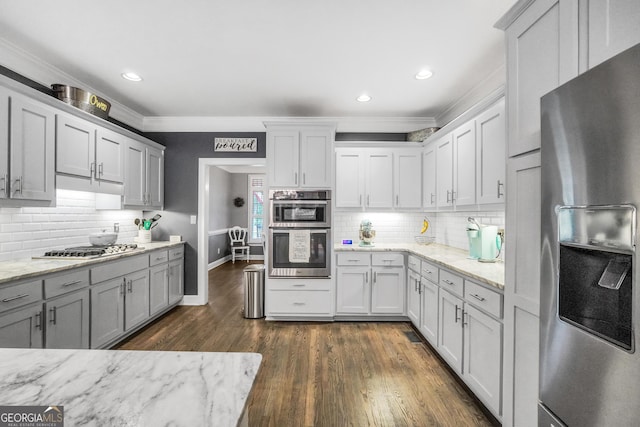 704 Branchview Ct, Mcdonough, GA 30252 - kitchen with appliances with stainless steel finishes, ornamental molding, decorative backsplash, dark wood-type flooring, and light stone countertops