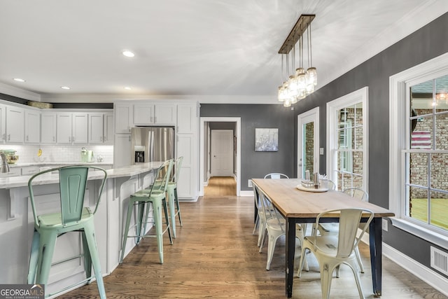 704 Branchview Ct, Mcdonough, GA 30252 - kitchen featuring stainless steel fridge, crown molding, baseboards, white cabinetry, and pendant lighting