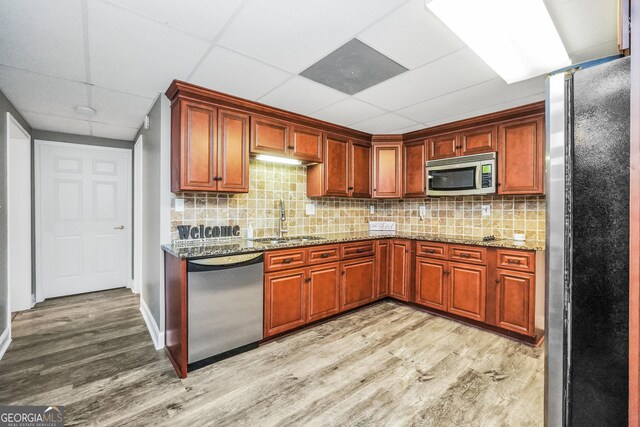 704 Branchview Ct, Mcdonough, GA 30252 - kitchen featuring appliances with stainless steel finishes, a sink, light wood finished floors, backsplash, and a drop ceiling