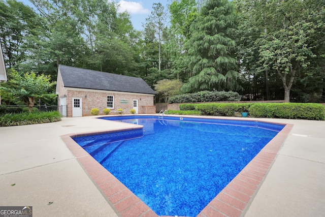 704 Branchview Ct, Mcdonough, GA 30252 - swimming pool with an outbuilding, a patio, and view of wooded area