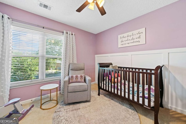 2346 Unicoi Ct, Duluth, GA 30097 - bedroom featuring multiple windows, a crib, carpet flooring, a textured ceiling, and ceiling fan