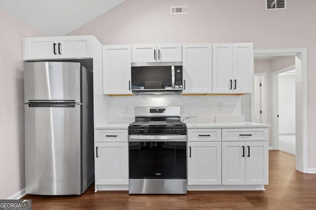5 Windsor Ter, Avondale Estates, GA 30002 - kitchen with appliances with stainless steel finishes, white cabinets, backsplash, dark wood-style flooring, and vaulted ceiling