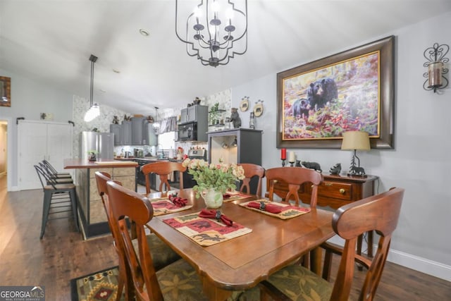 287 Napier Dr, Eatonton, GA 31024 - dining room with a chandelier, dark wood finished floors, vaulted ceiling, and baseboards