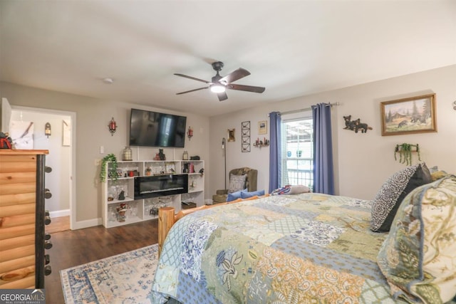 287 Napier Dr, Eatonton, GA 31024 - bedroom with wood finished floors, ceiling fan, baseboards, and a tiled fireplace
