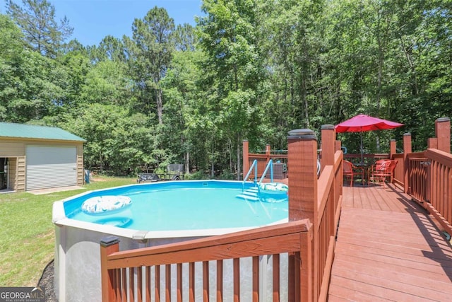 287 Napier Dr, Eatonton, GA 31024 - swimming pool featuring a deck, outdoor dining area, an outbuilding, and a yard