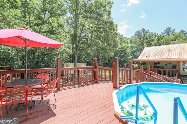287 Napier Dr, Eatonton, GA 31024 - deck featuring outdoor dining area, an outdoor pool, and view of wooded area