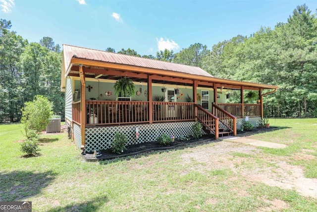 287 Napier Dr, Eatonton, GA 31024 - view of front of house featuring a front yard, central AC, a porch, and metal roof