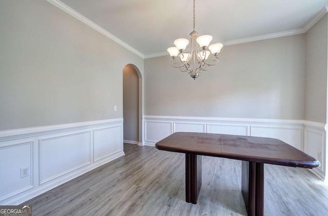26 Ivey Meadow Dr, Dallas, GA 30132 - unfurnished dining area with arched walkways, a chandelier, wood finished floors, crown molding, and a decorative wall