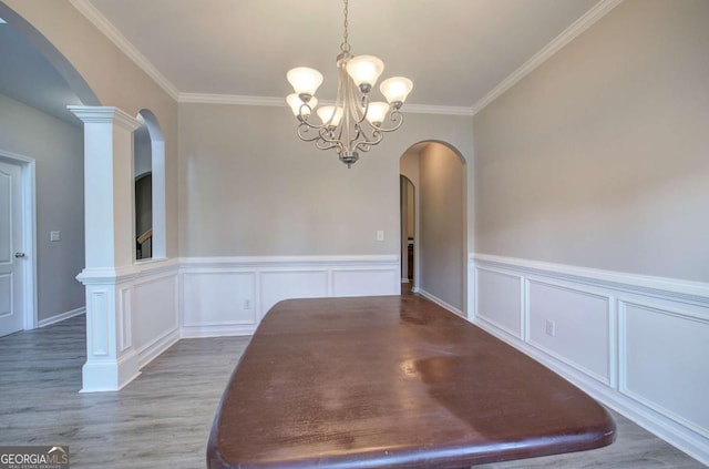 26 Ivey Meadow Dr, Dallas, GA 30132 - unfurnished dining area featuring wood finished floors, arched walkways, a chandelier, ornamental molding, and a wainscoted wall