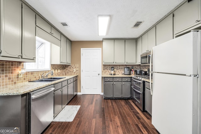 130 Nicki Ct, Hampton, GA 30228 - kitchen with appliances with stainless steel finishes, a sink, gray cabinets, dark wood-type flooring, and decorative backsplash