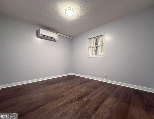 712 Boy Scout Rd, Newnan, GA 30263 - empty room featuring a wall mounted AC, dark wood-style flooring, baseboards, and a textured ceiling