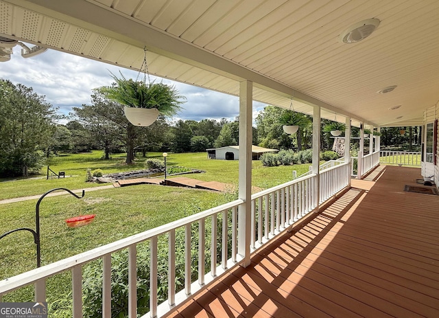 712 Boy Scout Rd, Newnan, GA 30263 - porch featuring a lawn, an outdoor structure, and view of wooded area