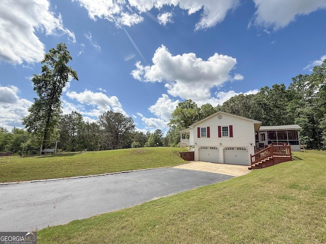 712 Boy Scout Rd, Newnan, GA 30263 - view of side of home with asphalt driveway, a garage, a sunroom, and a yard