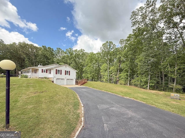 712 Boy Scout Rd, Newnan, GA 30263 - view of front facade featuring an attached garage, driveway, a wooded view, and a front lawn