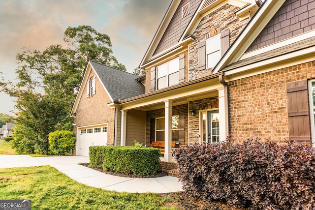 632 Creekside Trce, Covington, GA 30014 - view of side of home with a porch, a garage, stone siding, a shingled roof, and a yard