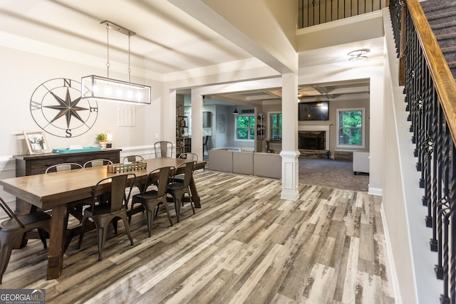632 Creekside Trce, Covington, GA 30014 - dining space with light wood-style floors, stairway, a fireplace with raised hearth, and crown molding